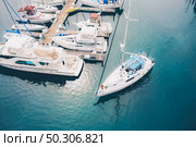 A white boat leaving the marina docks sailing on the water. White boat leaving the marina docks sailing on the water. Стоковое фото, агентство Ingram Publishing / Фотобанк Лори