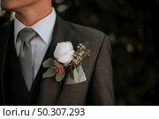A closeup shot of a male wearing a tuxedo with a boutonniere in its pocket. Closeup shot of a male wearing a tuxedo with a boutonniere in its pocket. Стоковое фото, агентство Ingram Publishing / Фотобанк Лори