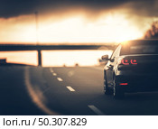 Highway Car Trip. Small Compact Car on the Highway During Sunset. Стоковое фото, агентство Ingram Publishing / Фотобанк Лори