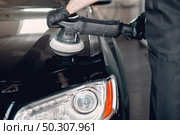 Man in a garage. Worker polish a car. Стоковое фото, агентство Ingram Publishing / Фотобанк Лори