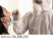 Medical staff with PPE suit test coronavirus covid-19 to asian woman by nose swab at hosputal. COVID-19 testing health care concept. Стоковое фото, агентство Ingram Publishing / Фотобанк Лори