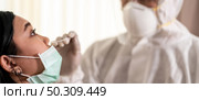 Panorama Medical staff with PPE suit test coronavirus covid-19 to asian woman by nose swab at hosputal. COVID-19 testing health care concept. Стоковое фото, агентство Ingram Publishing / Фотобанк Лори