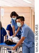 Close up Medical team do CPR to seriously injured patient with oxygen mask while push gurney stretcher bed to Operating Room. Emergency health care and medical hospital concept. Стоковое фото, агентство Ingram Publishing / Фотобанк Лори