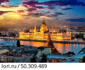 Hungarian parliament on riverbank of Danube illuminated in evening, Budapest. Стоковое фото, агентство Ingram Publishing / Фотобанк Лори