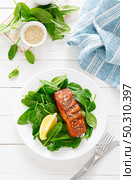 Salmon fish fillet grilled and fresh spinach salad on plate for lunch. Top view. Стоковое фото, агентство Ingram Publishing / Фотобанк Лори