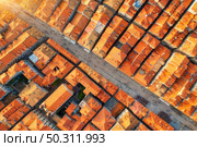 Aerial view of houses with orange roofs at sunset in summer in Dubrovnik, Croatia. Top view of beautiful architecture in old city. Historical centre, buildings, walking people on the street. Travel. Стоковое фото, агентство Ingram Publishing / Фотобанк Лори