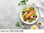 Salmon fish salad. Fresh vegetable greek salad with tomato, pepper, lettuce, olives, cucumbers, feta cheese and grilled salmon fish fillet in bowl, healthy food, omega 3, keto diet, mediterranean cusine, top view. Стоковое фото, агентство Ingram Publishing / Фотобанк Лори