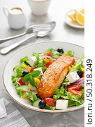 Salmon fish salad. Fresh vegetable greek salad with tomato, pepper, lettuce, olives, cucumbers, feta cheese and grilled salmon fish fillet in bowl, healthy food, omega 3, keto diet, mediterranean cusine. Стоковое фото, агентство Ingram Publishing / Фотобанк Лори