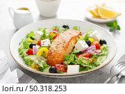 Salmon fish salad. Fresh vegetable greek salad with tomato, pepper, lettuce, olives, cucumbers, feta cheese and grilled salmon fish fillet in bowl, healthy food, omega 3, keto diet, mediterranean cusine. Стоковое фото, агентство Ingram Publishing / Фотобанк Лори