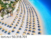 Aerial view of sea, empty sandy beach with sunbeds and umbrellas at sunny day in summer. Blue lagoon in Oludeniz, Turkey. Tropical landscape with clear turquoise water, deck chairs. Travel and leisure. Стоковое фото, агентство Ingram Publishing / Фотобанк Лори