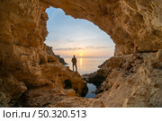 Man in sea grotto. Sea cave mainsail nature landsacpe. . Стоковое фото, агентство Ingram Publishing / Фотобанк Лори