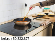 person mixing sauce pan stove. Стоковое фото, агентство Ingram Publishing / Фотобанк Лори