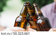 close up friends clinking brown beer bottles. Стоковое фото, агентство Ingram Publishing / Фотобанк Лори