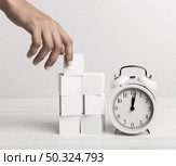 hand putting white cubes clock. Стоковое фото, агентство Ingram Publishing / Фотобанк Лори