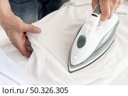man ironing clothes close up. Resolution and high quality beautiful photo. man ironing clothes close up. High quality beautiful photo concept. Стоковое фото, агентство Ingram Publishing / Фотобанк Лори