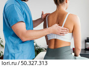 side view male osteopathic therapist checking female patient s scapula bone. High resolution photo. side view male osteopathic therapist checking female patient s scapula bone. High quality photo. Стоковое фото, агентство Ingram Publishing / Фотобанк Лори
