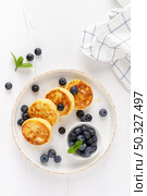 Cottage cheese or curd fritters with honey and fresh blueberry. Healthy diet food, breakfast. Top view. Стоковое фото, агентство Ingram Publishing / Фотобанк Лори