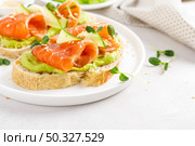 Open sandwiches with salted salmon, guacamole avocado and microgreens. Seafood. Healthy food. Стоковое фото, агентство Ingram Publishing / Фотобанк Лори