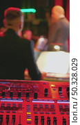 A mesmerizing live performance environment demonstrating the intricate controls of a mixing console. In the background, a bandleader directs the orchestra. Стоковое видео, видеограф Воловодов Владимир / Фотобанк Лори