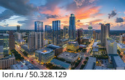 A panoramic view of a city bathed in the glow of the setting sun, captured from a birds eye perspective. Стоковое AI-изображение, AI-художник Данила Большаков / Фотобанк Лори