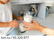 mother hand offering glass milk. High resolution photo. mother hand offering glass milk. High quality photo. Стоковое фото, агентство Ingram Publishing / Фотобанк Лори