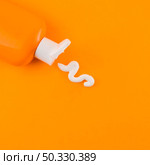 OLYMPUS DIGITAL CAMERA. High resolution photo. white sunscreen cream coming out orange bottle against orange backdrop. High quality photo. Стоковое фото, агентство Ingram Publishing / Фотобанк Лори