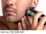man shaving with black trimmer. Стоковое фото, агентство Ingram Publishing / Фотобанк Лори