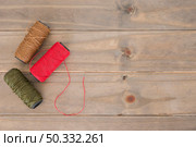 red brown green yarn spool wooden table. High resolution photo. red brown green yarn spool wooden table. High quality photo. Стоковое фото, агентство Ingram Publishing / Фотобанк Лори