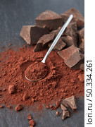From above of organic dark bitter cocoa powder with teaspoon and heap of chocolate chunks on gray background. Delicious chocolate and cocoa powder. Стоковое фото, агентство Ingram Publishing / Фотобанк Лори