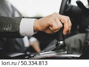 close up businessman s hand gripping gear car. Стоковое фото, агентство Ingram Publishing / Фотобанк Лори