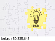 yellow idea jigsaw puzzle stand out from white pieces. Стоковое фото, агентство Ingram Publishing / Фотобанк Лори