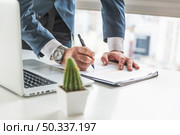 businessman writing document with pen desk with laptop. Стоковое фото, агентство Ingram Publishing / Фотобанк Лори