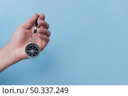 close up human hand holding navigational compass blue backdrop. Стоковое фото, агентство Ingram Publishing / Фотобанк Лори