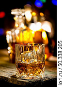 Glass of whiskey and decanter on wooden table. Стоковое фото, агентство Ingram Publishing / Фотобанк Лори