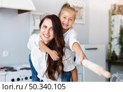 happy mother daughter posing with kitchen roller. Стоковое фото, агентство Ingram Publishing / Фотобанк Лори