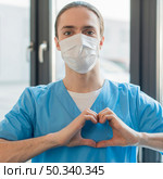 nurse male with medical mask showing heart shape. Стоковое фото, агентство Ingram Publishing / Фотобанк Лори