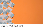 top view white tea bags orange background with space writing text. Стоковое фото, агентство Ingram Publishing / Фотобанк Лори
