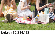 close up women sitting green grass enjoying picnic. Стоковое фото, агентство Ingram Publishing / Фотобанк Лори
