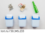 sorting trash into separate garbage cans. Стоковое фото, агентство Ingram Publishing / Фотобанк Лори