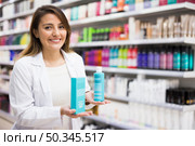 Positive salesgirl helping to choose hair products in cosmetic store. Стоковое фото, фотограф Татьяна Яцевич / Фотобанк Лори
