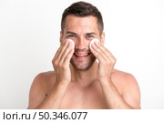 shirtless man cleaning his face with batting cotton pads white background looking camera. Стоковое фото, агентство Ingram Publishing / Фотобанк Лори