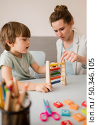 side view tutor teaching child how use abacus. Стоковое фото, агентство Ingram Publishing / Фотобанк Лори