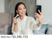 smiley woman vlogging with make up brush. Стоковое фото, агентство Ingram Publishing / Фотобанк Лори