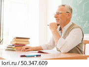elderly lecturer sitting desk auditorium. Стоковое фото, агентство Ingram Publishing / Фотобанк Лори