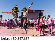 excited young women jumping air celebrating holi festival. Стоковое фото, агентство Ingram Publishing / Фотобанк Лори