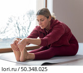 indoors mature woman touching her feet. Стоковое фото, агентство Ingram Publishing / Фотобанк Лори