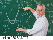 senior teacher glasses explaining math example green chalkboard. Стоковое фото, агентство Ingram Publishing / Фотобанк Лори