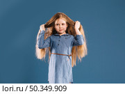 cute girl touching hair. Стоковое фото, агентство Ingram Publishing / Фотобанк Лори