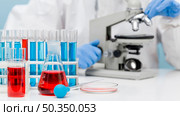scientist checking substance with microscope. Стоковое фото, агентство Ingram Publishing / Фотобанк Лори