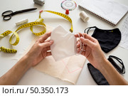 woman holding face mask she sew. Стоковое фото, агентство Ingram Publishing / Фотобанк Лори